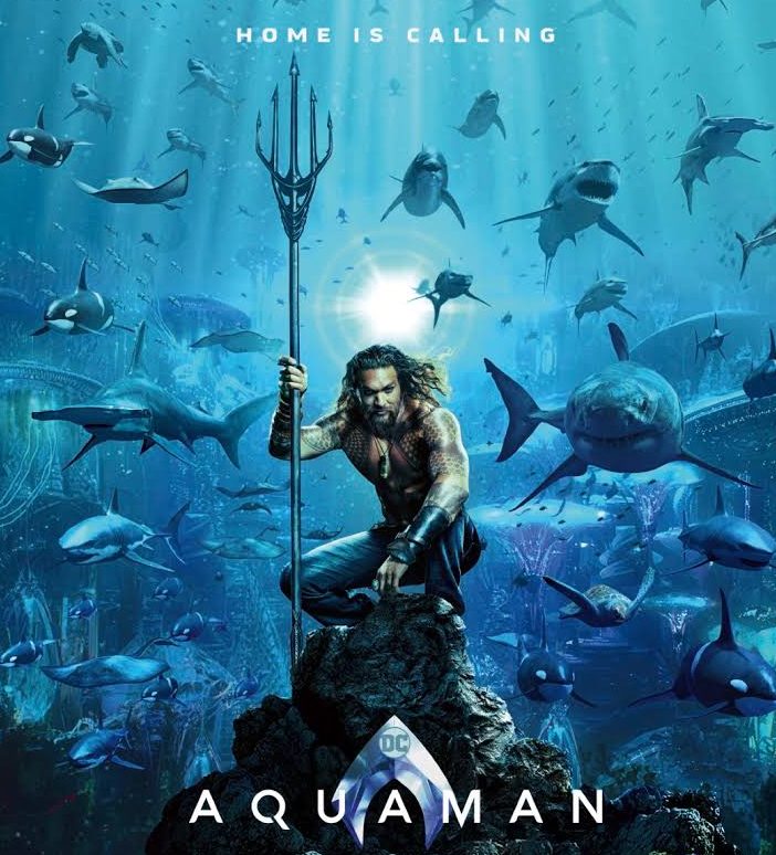 Poster zum Aquaman Film und einem unter Wasser knieenden Jason Momoa, umgeben von Haien.
