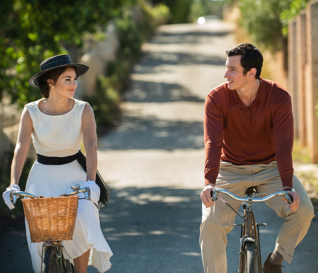 Filmausschnitt aus Eine Handvoll Worte. Eine Frau und ein Mann fahren sommerlich gekleidet auf einem Fahrrad.