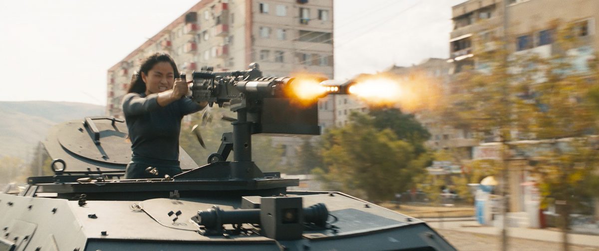 Mit einem Machinengewehr Aufsatz auf einem gepanzerten Fahrzeug, schießt sich eine Frau den Weg in Budapest frei