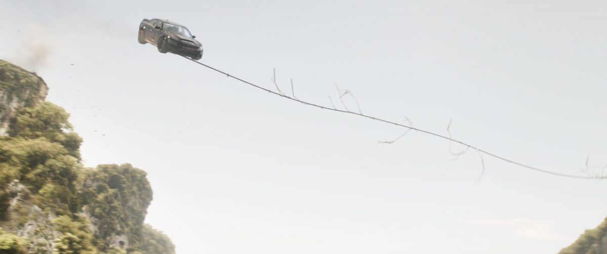 Ein Auto mit einem Stahlseil um die Vorderachse, schwingt sich über eine Schlucht