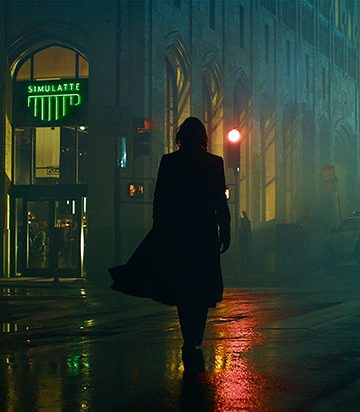 Keanu Reeves auf einer schwach beleuchteten Straße in The Matrix 4