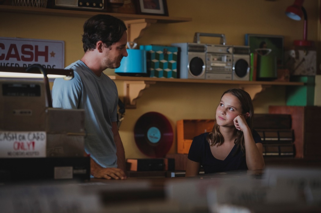 Laura (Clara Rugaard) und Harrison (Lewis Pullman) sprechen über Platten und Kassetten