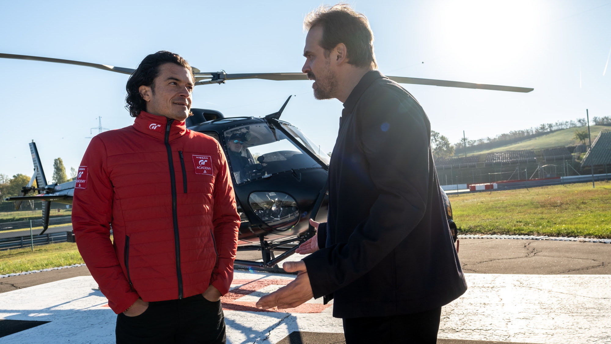 Jack (David Harbour, rechts) argumentiert mit Danny (Orlando Bloom) in den Hubschrauber zu steigen, um die Studenten der GT Academy zu beobachten